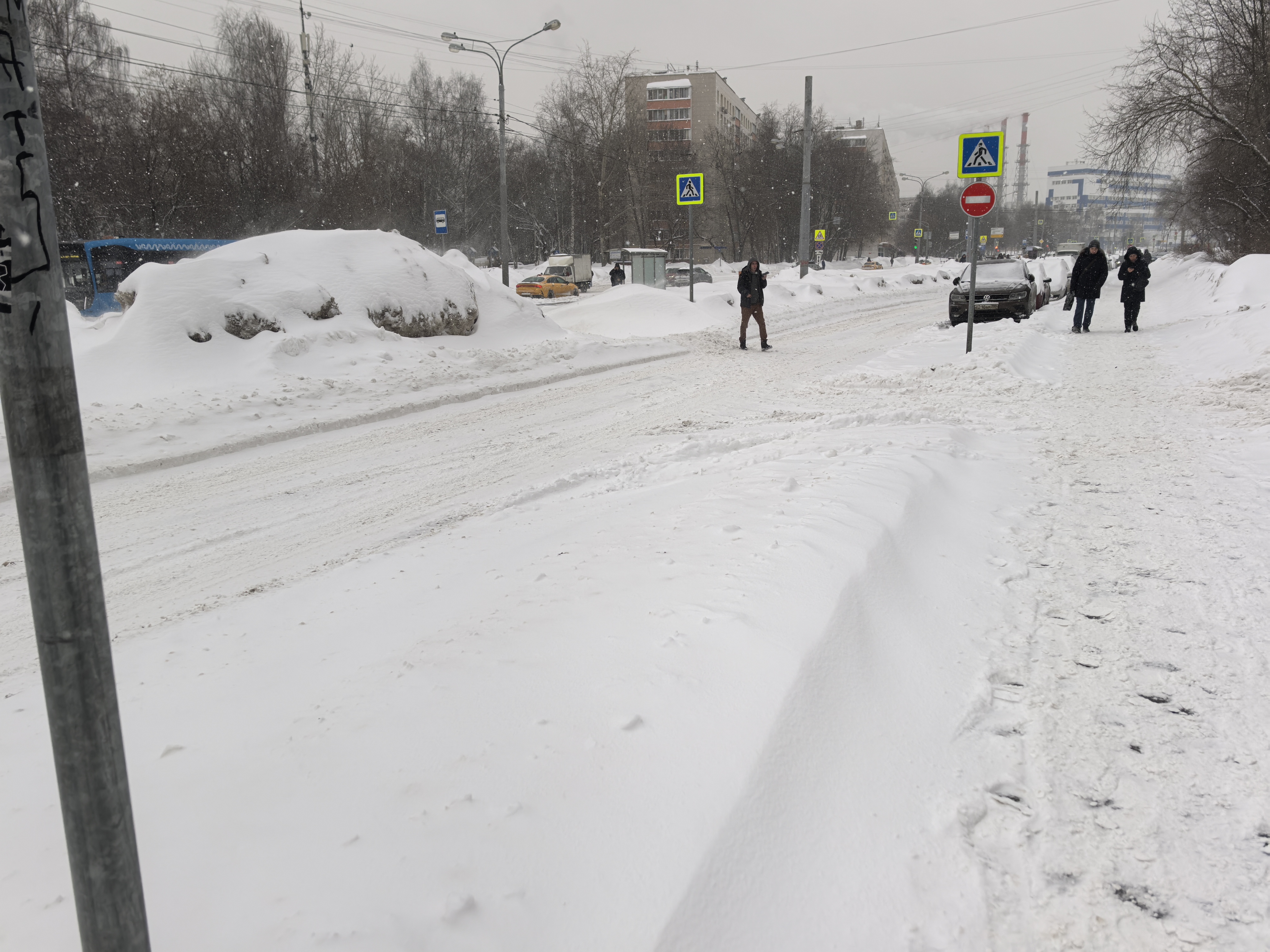 Проезжая часть с пешеходным переходом в зимних условиях, покрытая снегом