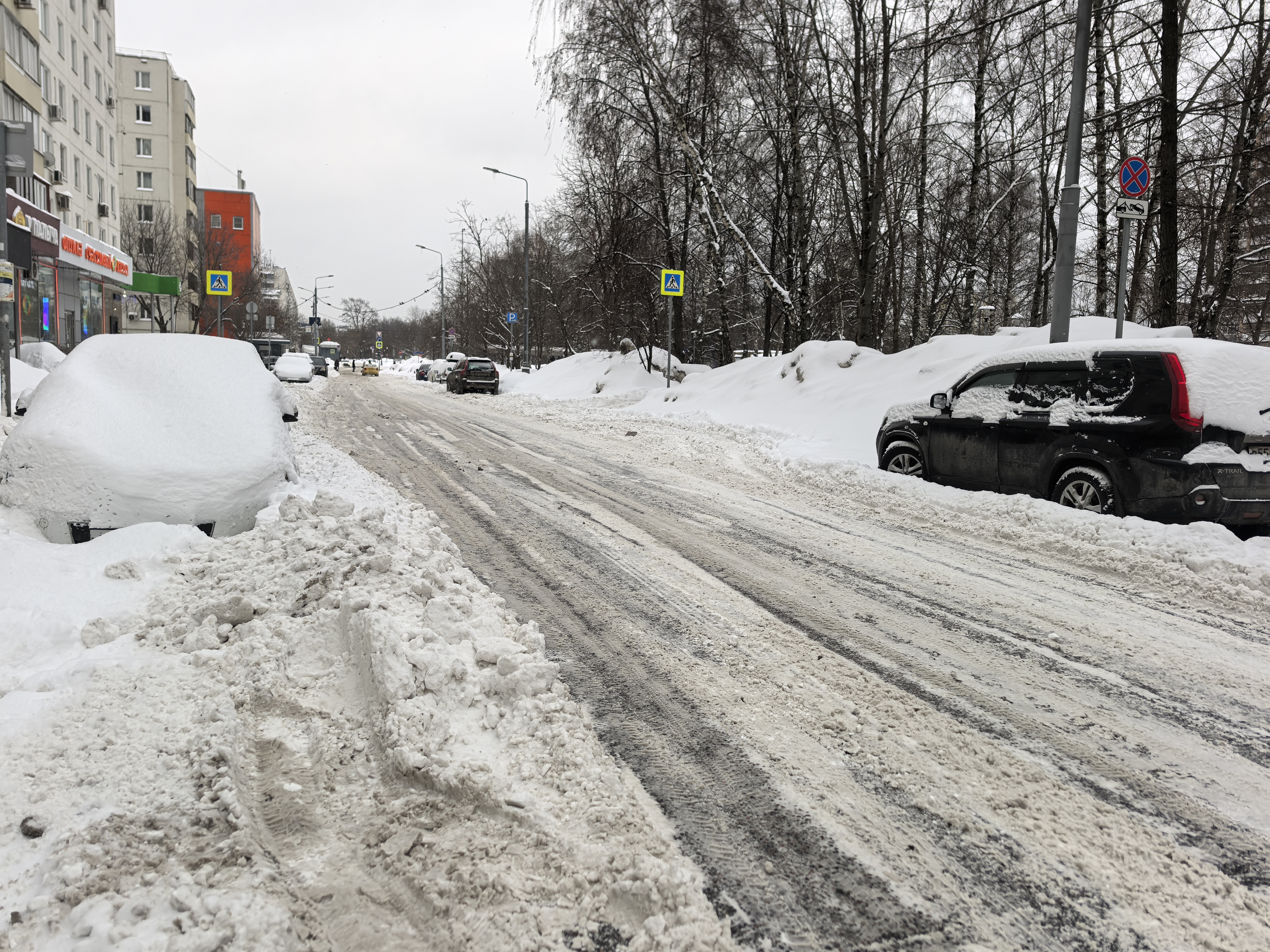 Проезжая часть без пешеходного перехода, зимние условия, припаркованные автомобили по обеим сторонам.
