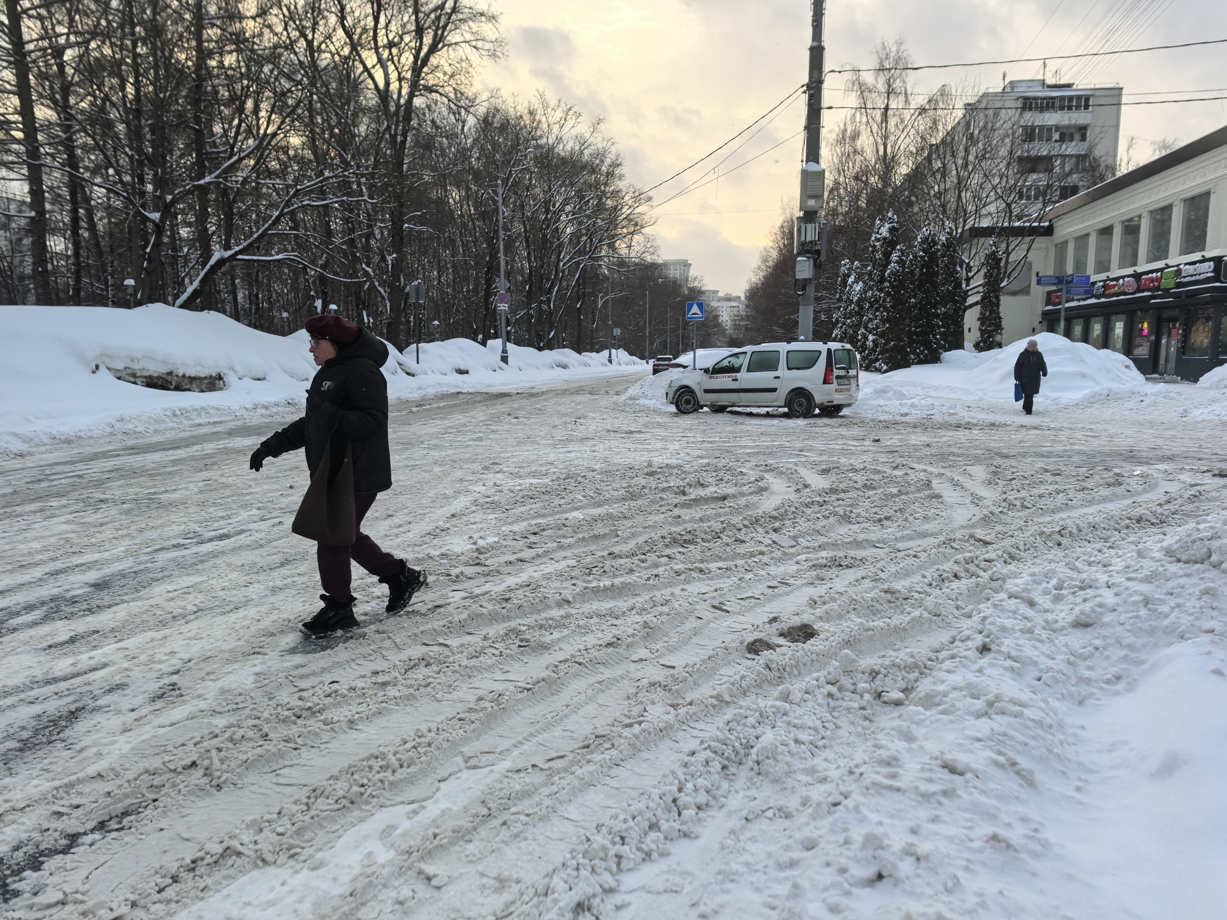 Участок дороги без пешеходного перехода, покрытый снегом и льдом. Тротуары частично засыпаны снегом, пешеходы вынуждены идти по проезжей части.