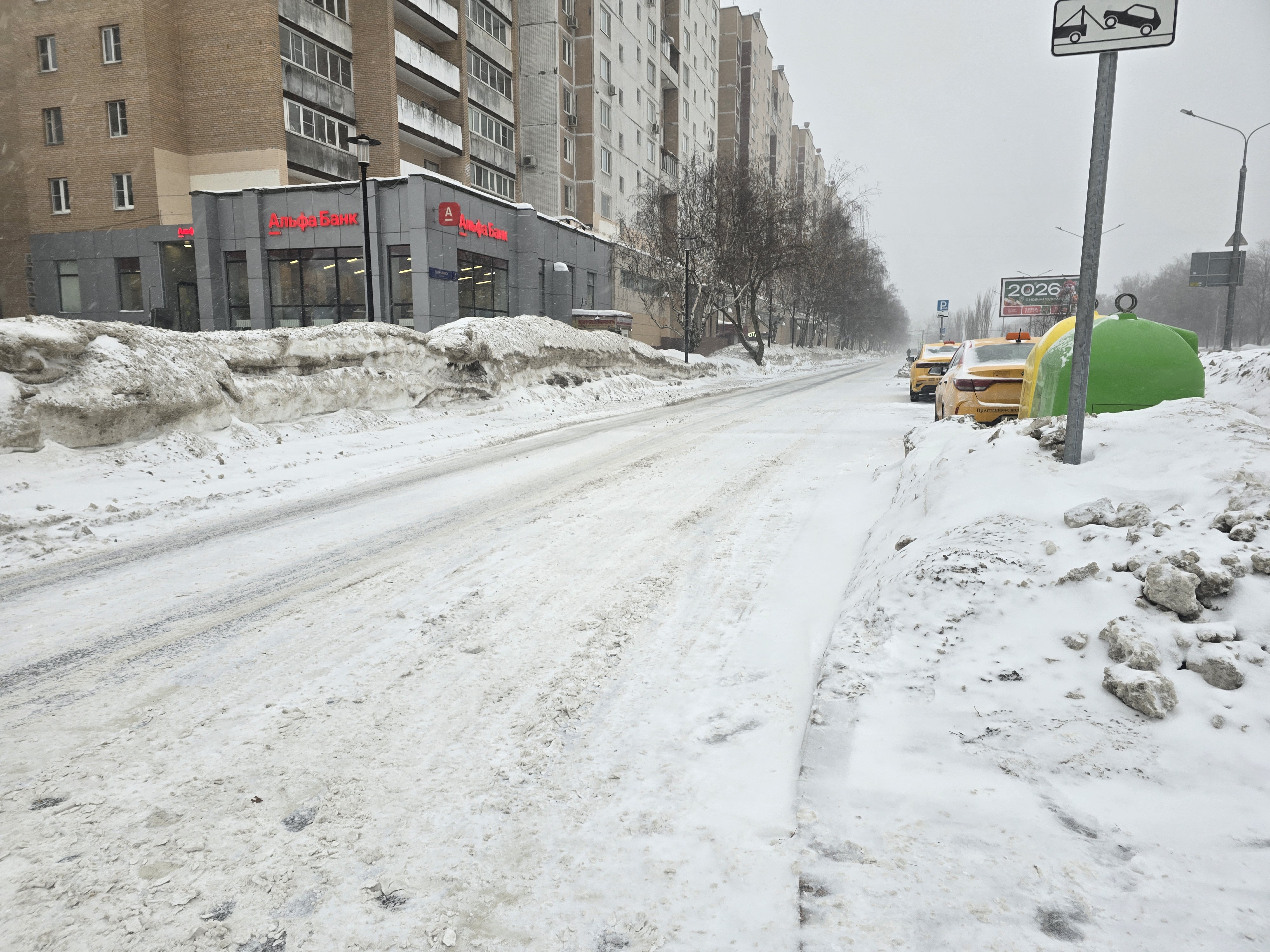Проезжая часть без пешеходного перехода, покрытая снегом и льдом, с припаркованными такси и высоким сугробом на обочине.