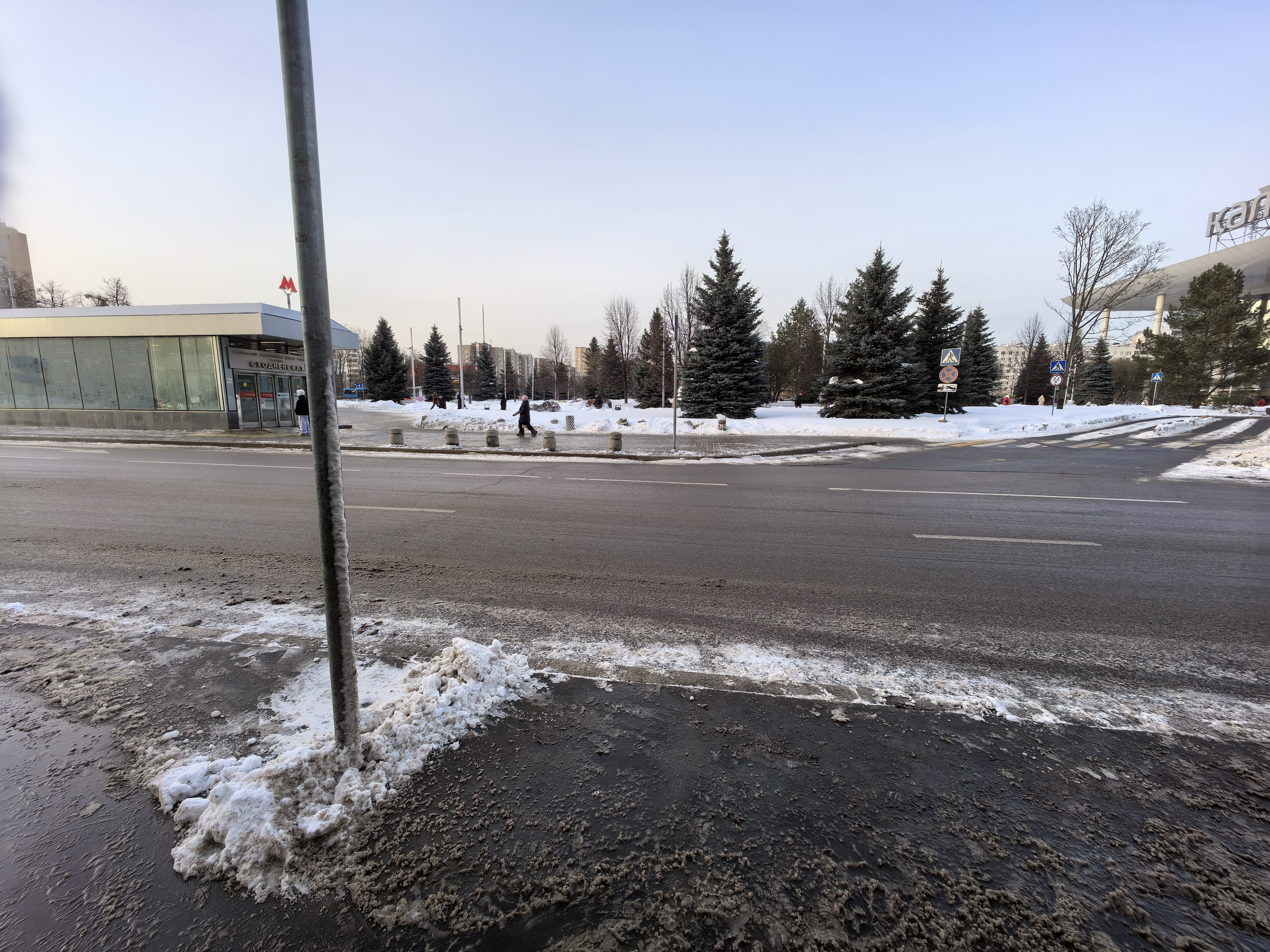 Проезжая часть с пешеходным переходом вблизи станции метро Сходненская. Видна разметка, знаки и тротуар, покрытый снегом.